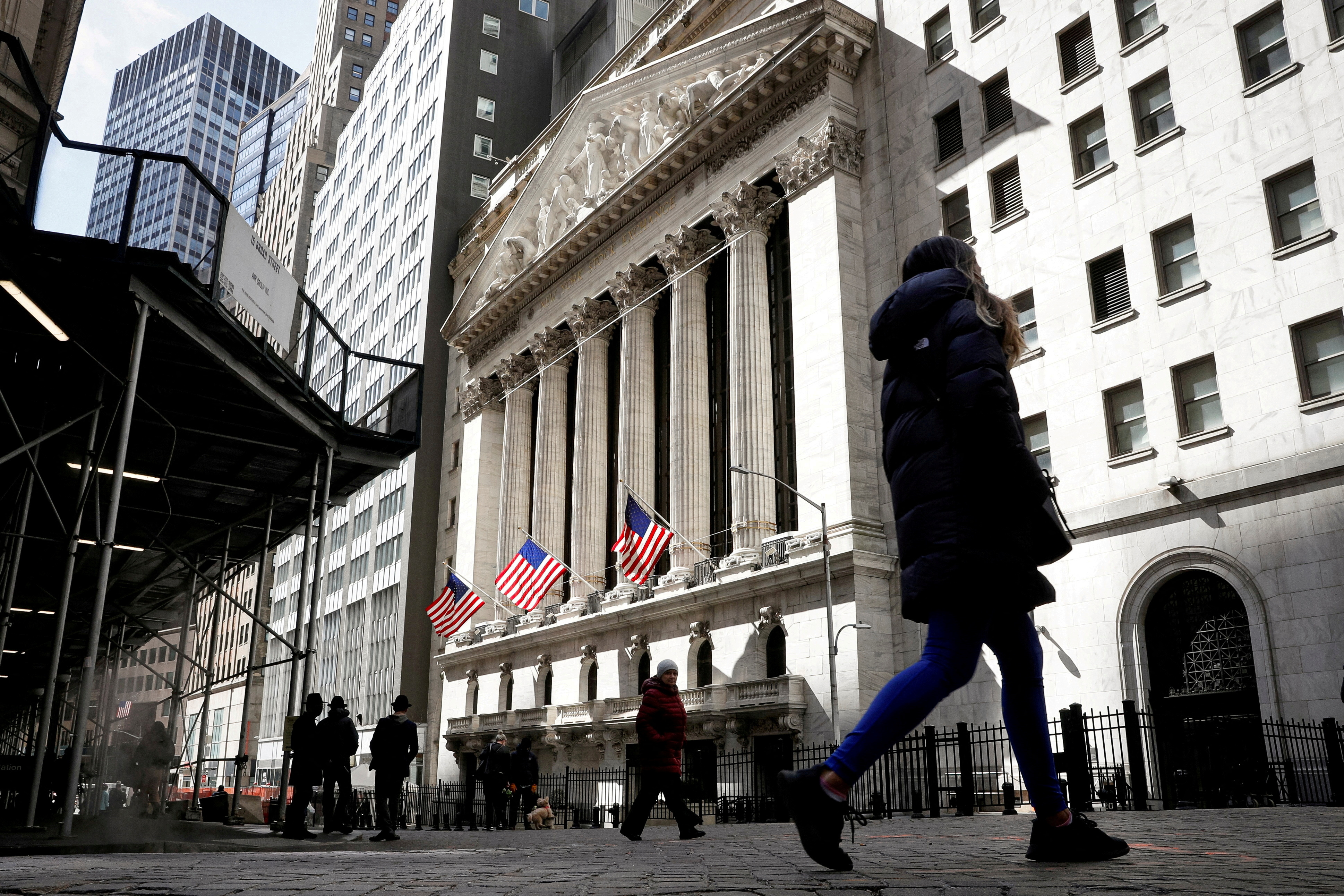 People are seen on Wall Street outside the NYSE in New York