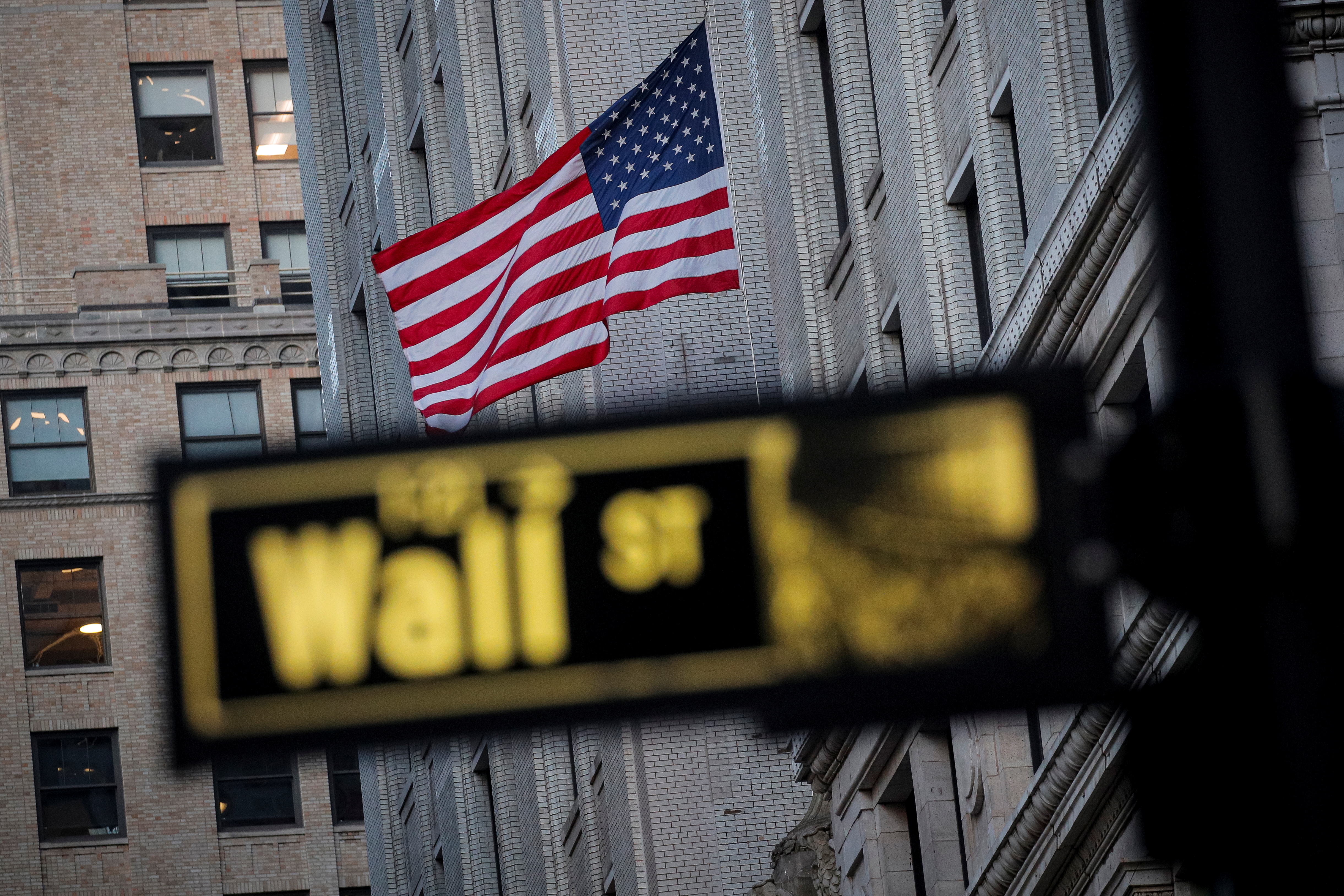 The U.S. flag is seen on a building on Wall St. in the financial district in New York