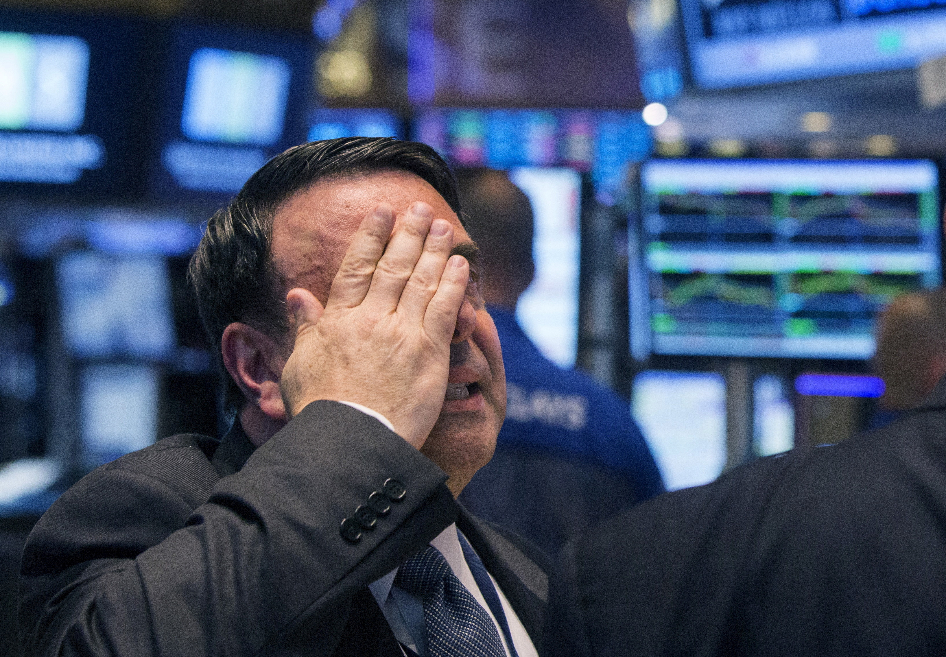 An NYSE official gestures after the resumption of trading following a several hour long stoppage on the floor of the New York Stock Exchange
